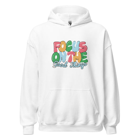 White hooded sweatshirt with a central graphic reading "Focus On The Good Things" in multi-color retro bubble letters with a light blue outline|IslandWear Fashion