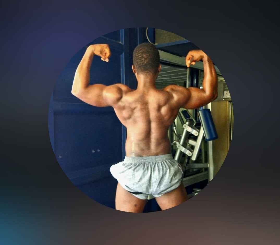 Man flexing muscles in a gym setting|IslandWear Fashion 