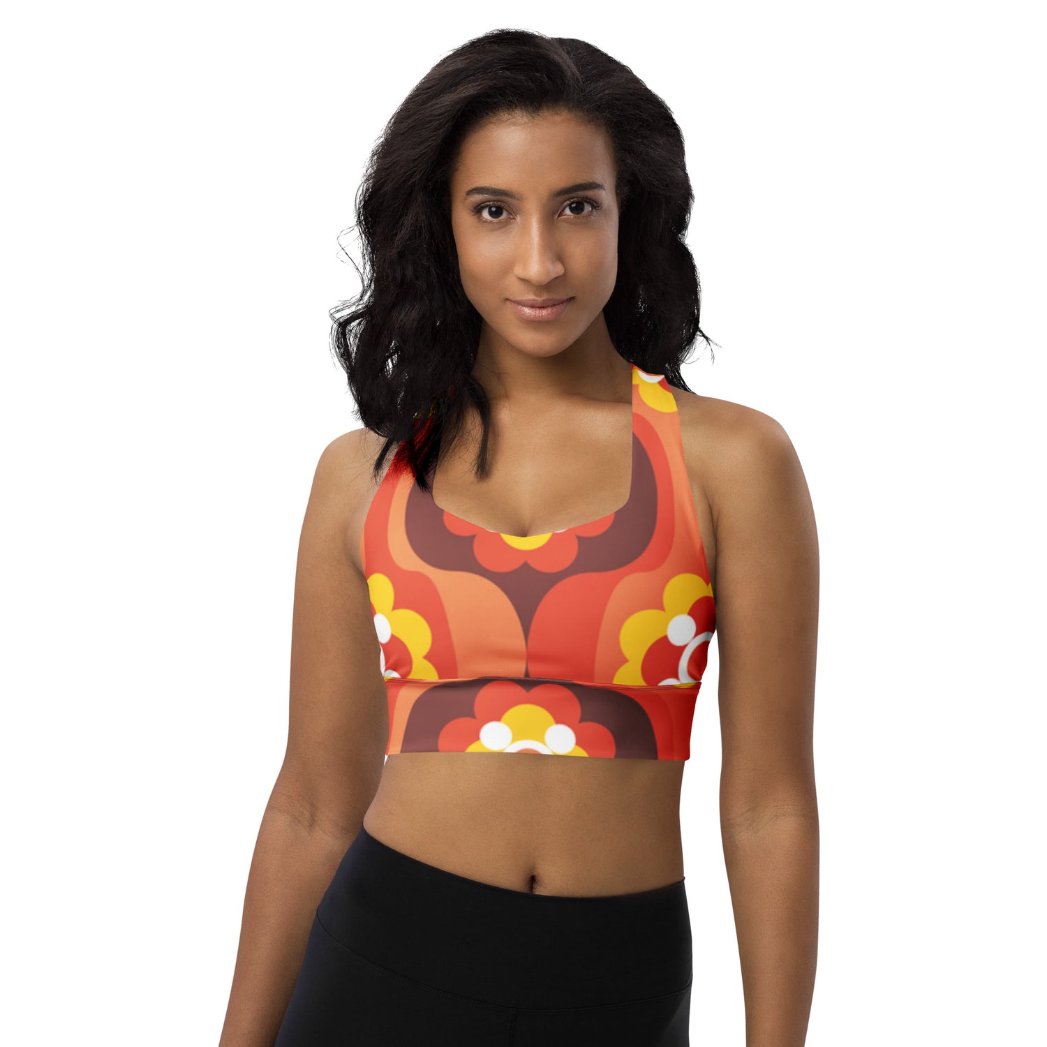 Woman wearing a colorful sports bra and black leggings on a white background