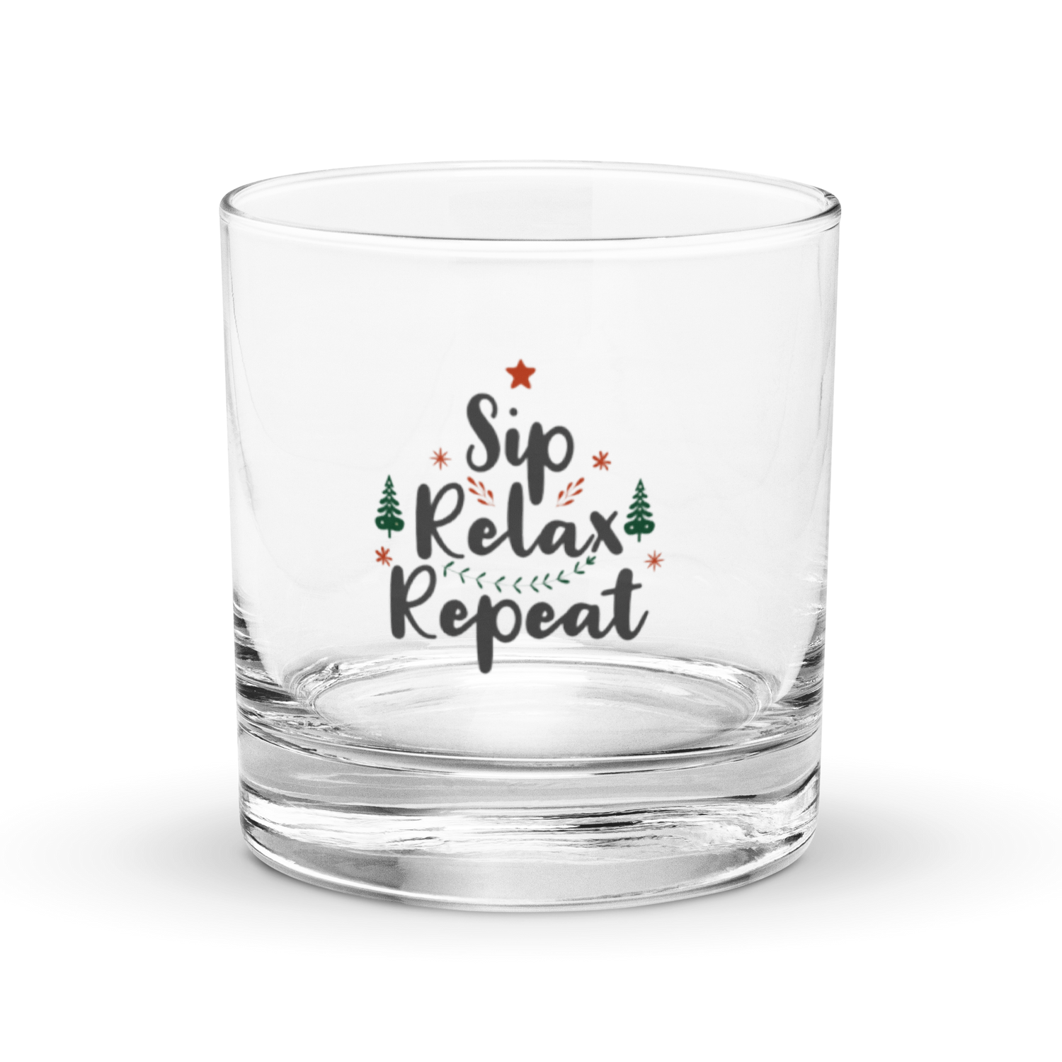 ​Clear, heavy-bottomed rocks glass or whiskey tumbler with a festive "Sip Relax Repeat" graphic, Christmas trees, and star | IslandWear Fashion 
