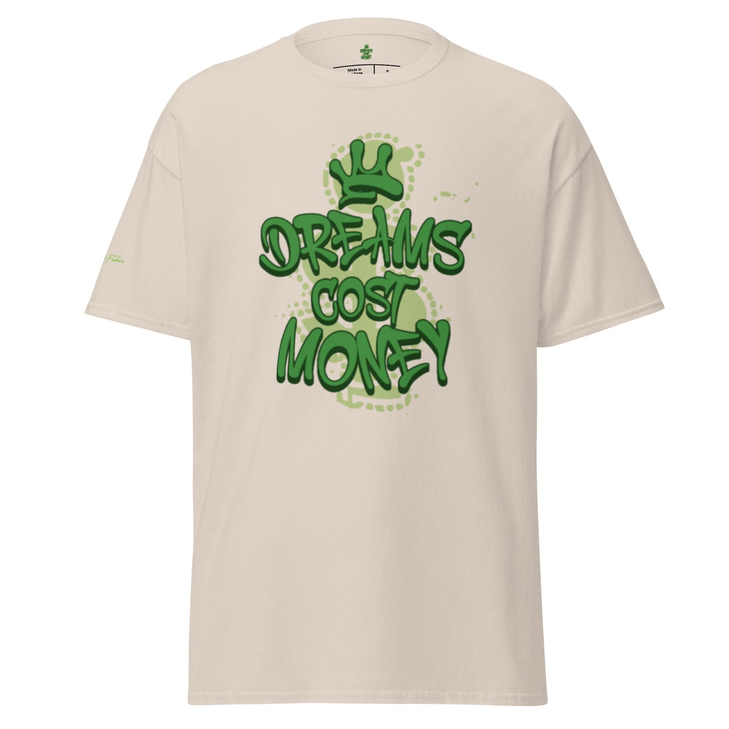 Beige/Natural unisex t-shirt featuring a streetwear graphic that reads "Dreams Cost Money" in bold, textured light green letters, overlaid on a faded money sign symbol. The design has white splatter accents.
